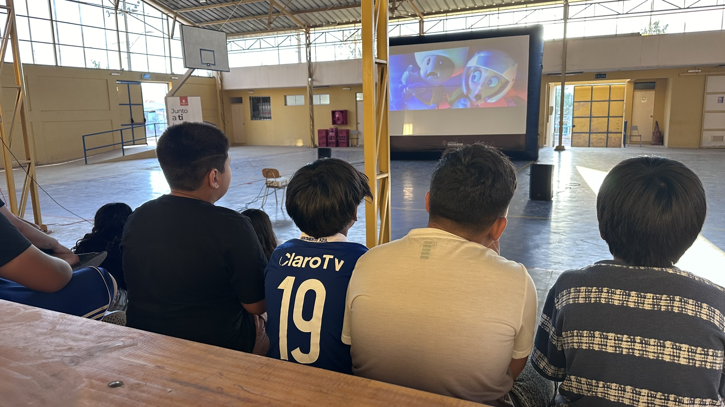 Familias de Inca de Oro disfrutan de tarde de cine con palomitas en pantalla gigante